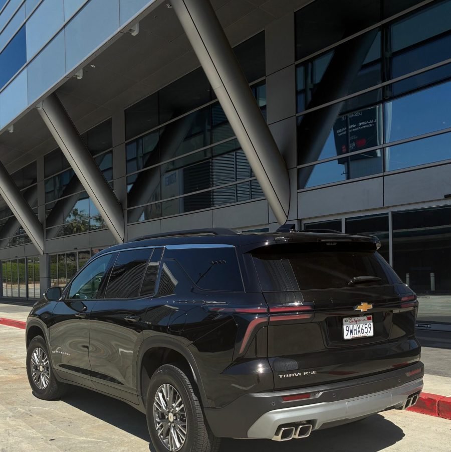JM Transportation Service - Black 2026 Chevrolet Traverse rear view parked at modern office building for corporate transportation service